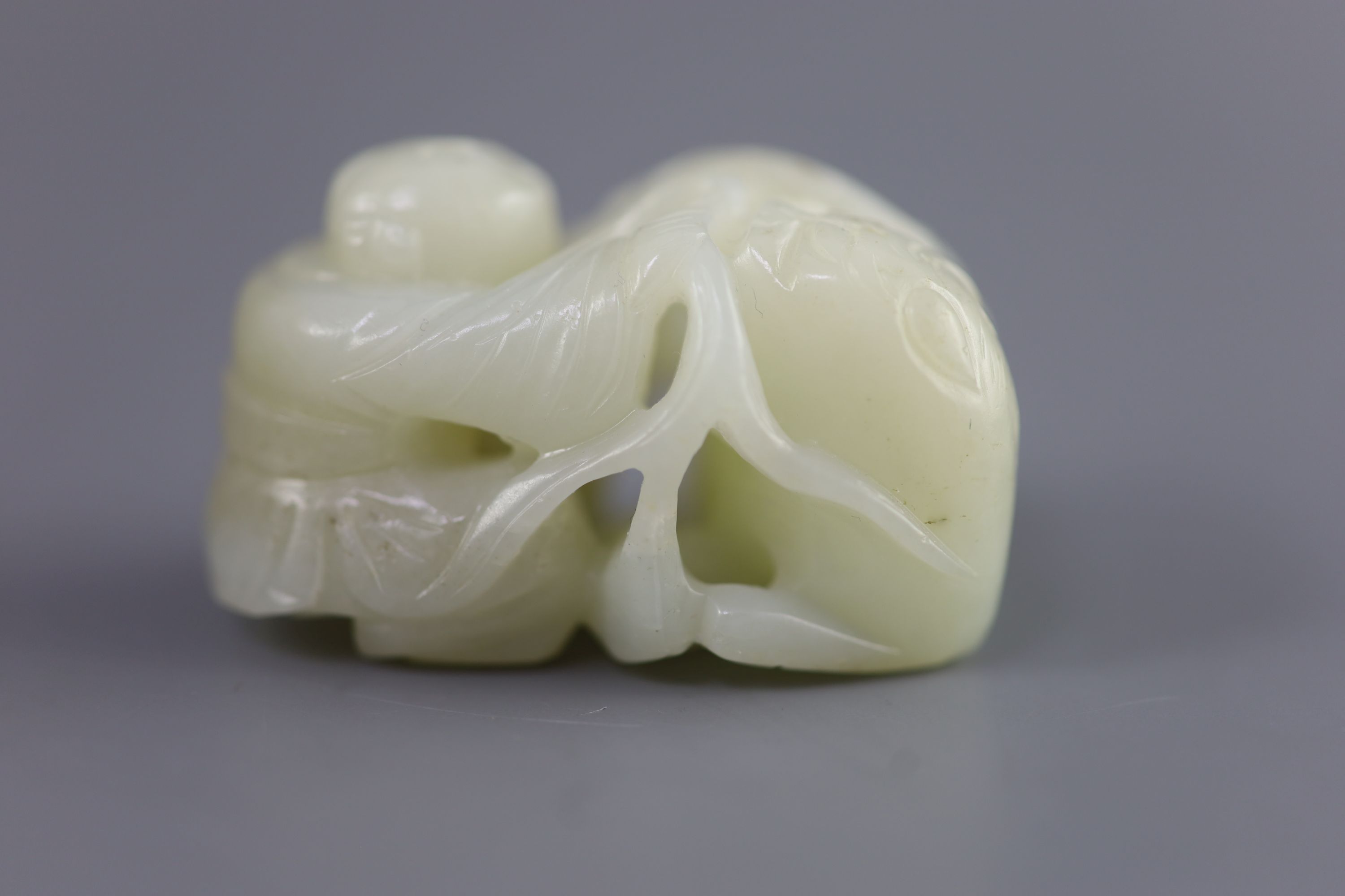 A Chinese pale celadon jade group of a boy and a lion-dog, 19th/20th century, 5.4cm